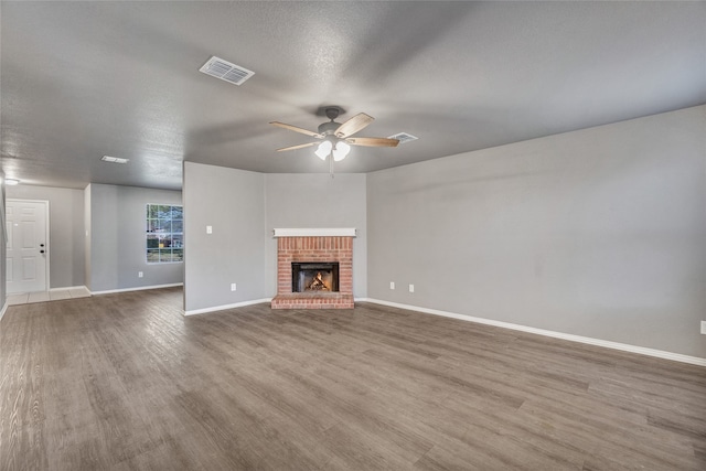 unfurnished living room featuring baseboards, a ceiling fan, wood finished floors, and visible vents