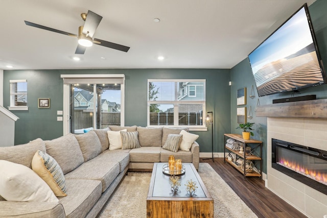 living room with ceiling fan, baseboards, a glass covered fireplace, recessed lighting, and wood finished floors