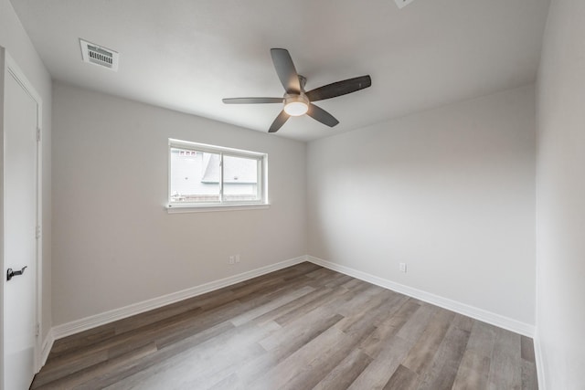 empty room with wood finished floors, visible vents, baseboards, and ceiling fan
