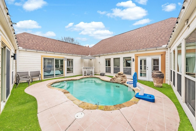 pool with french doors and a patio area