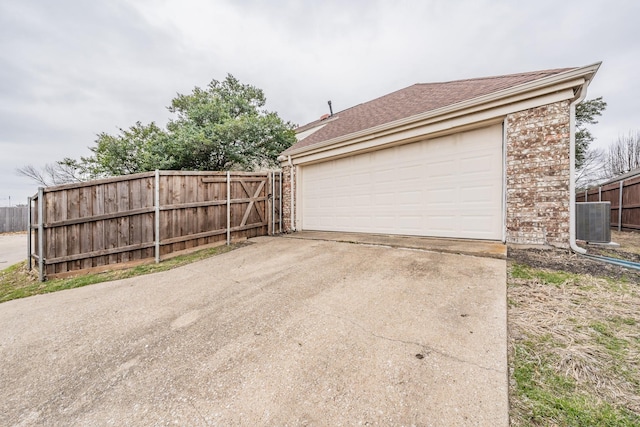 garage featuring central AC unit and fence