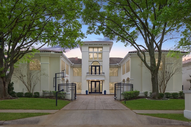 5608 Stone Cliff Ct, Dallas, TX 75287 - view of front of house featuring french doors, a tiled roof, a lawn, a balcony, and stucco siding