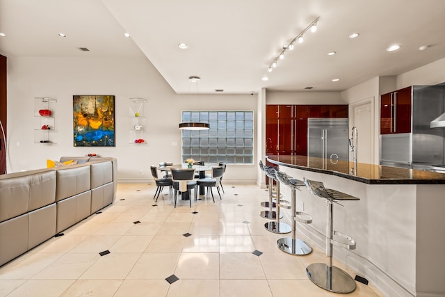 5608 Stone Cliff Ct, Dallas, TX 75287 - kitchen featuring dark brown cabinets, built in fridge, modern cabinets, a kitchen bar, and recessed lighting