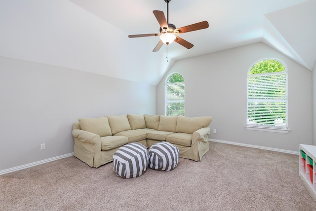 living area featuring lofted ceiling, carpet flooring, a ceiling fan, and baseboards