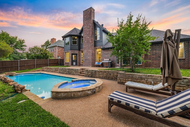 view of swimming pool featuring a patio, fence, a grill, and a pool with connected hot tub