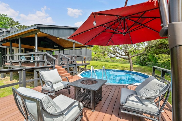 outdoor pool with a wooden deck, a yard, and a fire pit