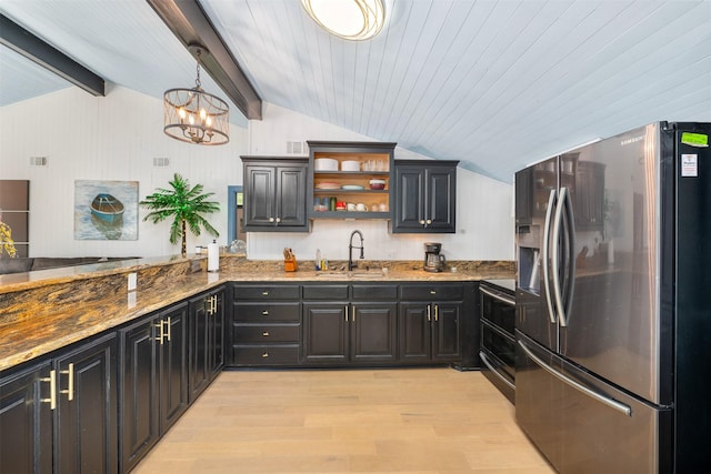 kitchen with lofted ceiling with beams, range with two ovens, a sink, and stainless steel fridge