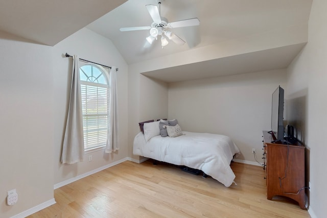 bedroom featuring light wood-type flooring, a ceiling fan, baseboards, and lofted ceiling