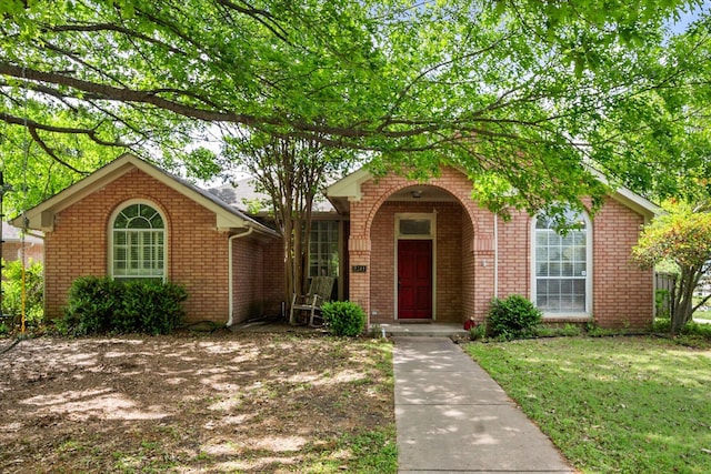 view of front of home featuring a front lawn and brick siding