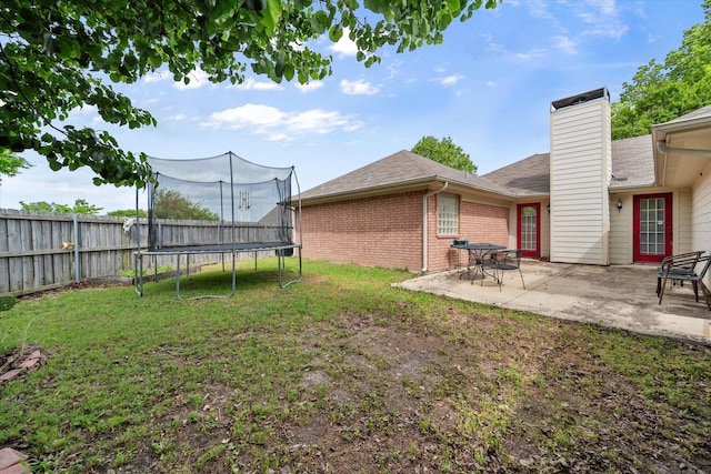 view of yard featuring a fenced backyard, a patio, and a trampoline