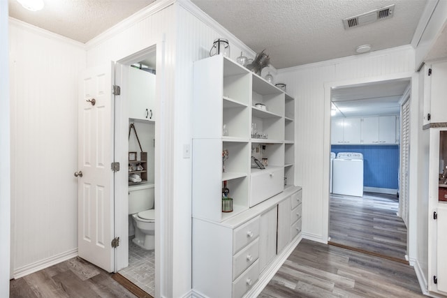 308 N Pecan St, Muenster, TX 76252 - spacious closet featuring wood finished floors, visible vents, and washing machine and clothes dryer