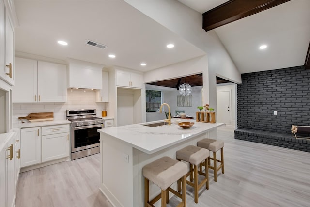 5925 Forest Haven Trl, Dallas, TX 75232 - kitchen featuring a sink, stainless steel gas range, light wood finished floors, white cabinets, and visible vents