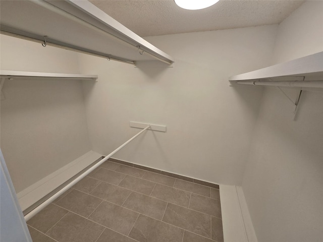spacious closet featuring dark tile patterned flooring