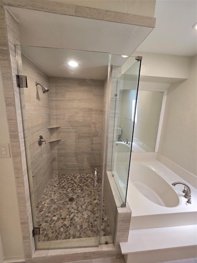 full bathroom featuring a shower stall, a garden tub, and recessed lighting