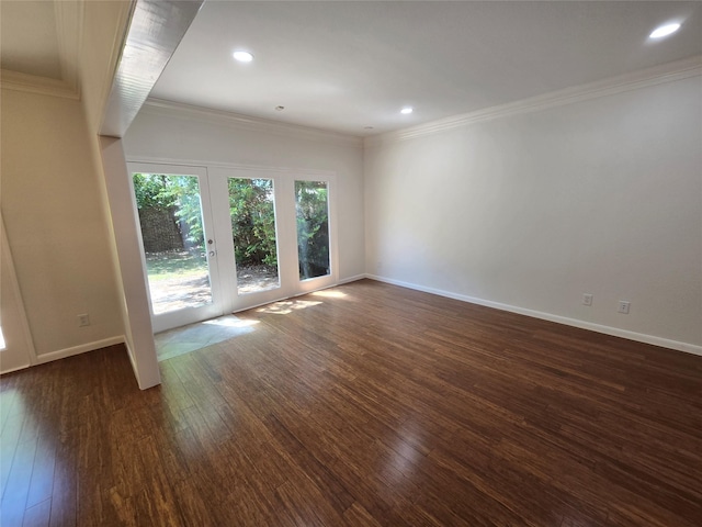 spare room with dark wood-type flooring, baseboards, and ornamental molding