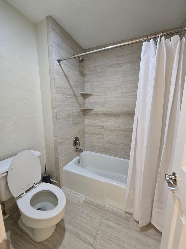 bathroom featuring shower / tub combo and toilet