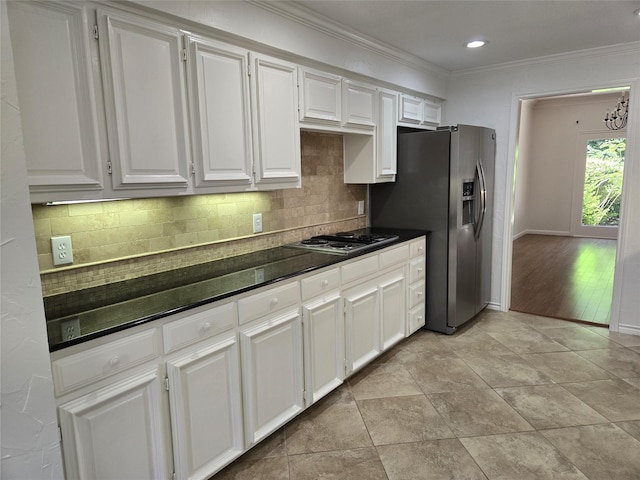 kitchen featuring electric cooktop, dark countertops, decorative backsplash, crown molding, and stainless steel refrigerator with ice dispenser