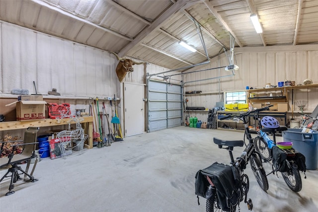 garage with metal wall, a workshop area, and a garage door opener