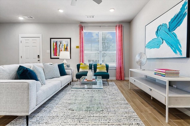 living area featuring wood finished floors, ceiling fan, baseboards, visible vents, and recessed lighting