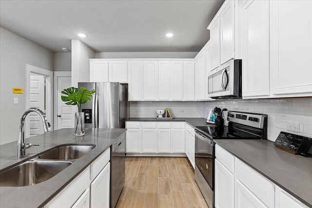 kitchen featuring white cabinets, tasteful backsplash, stainless steel appliances, and a sink