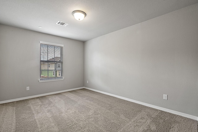 carpeted spare room with baseboards and visible vents