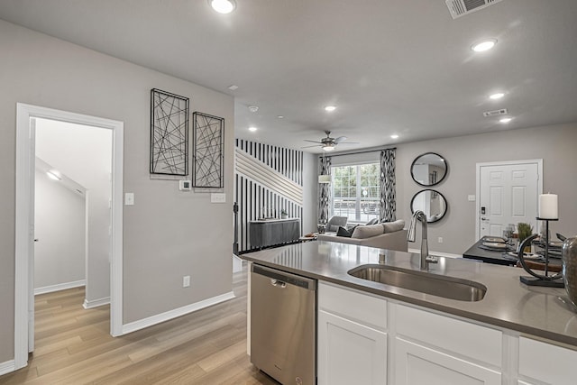kitchen with light wood finished floors, white cabinetry, stainless steel dishwasher, a sink, and ceiling fan