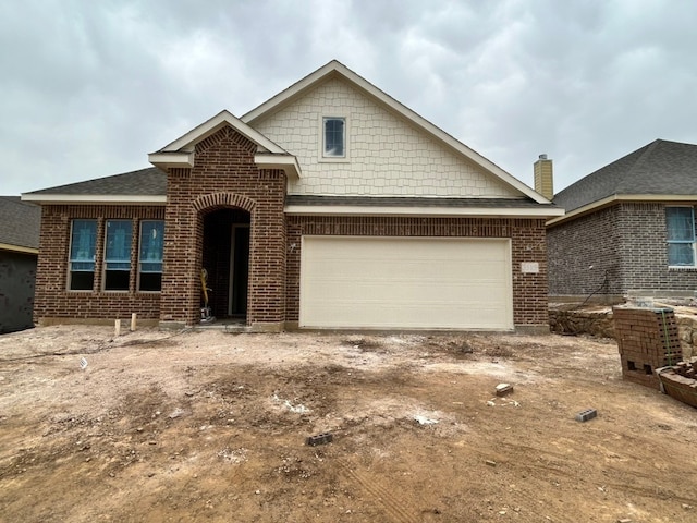 view of front of home with brick siding, driveway, and a garage