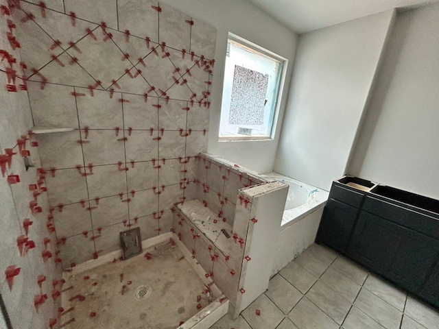 full bath with a garden tub and tile patterned flooring