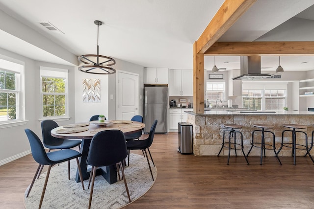 dining area featuring a wealth of natural light, visible vents, dark wood-style floors, and baseboards