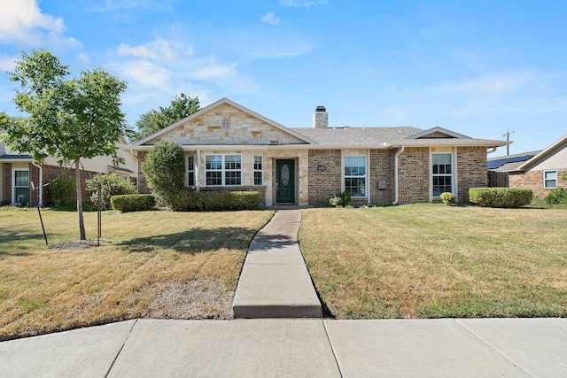 view of front of house with a chimney, a front lawn, and stone siding