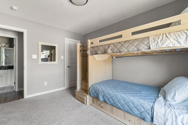 carpeted bedroom featuring baseboards and a sink