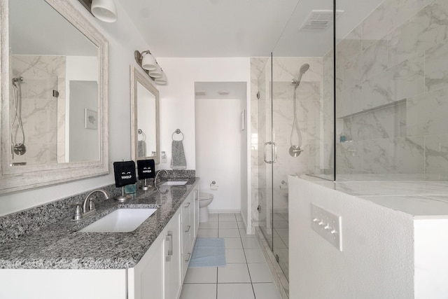 bathroom with a marble finish shower, toilet, a sink, and visible vents