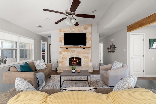 living room featuring wood finished floors, ceiling fan, a fireplace, lofted ceiling, and visible vents