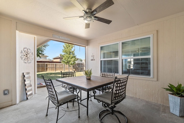 view of patio with outdoor dining area, fence, and ceiling fan