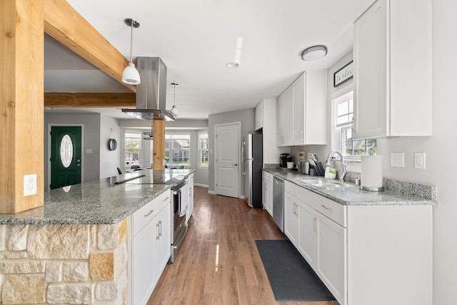 kitchen featuring white cabinets, island range hood, appliances with stainless steel finishes, and a sink