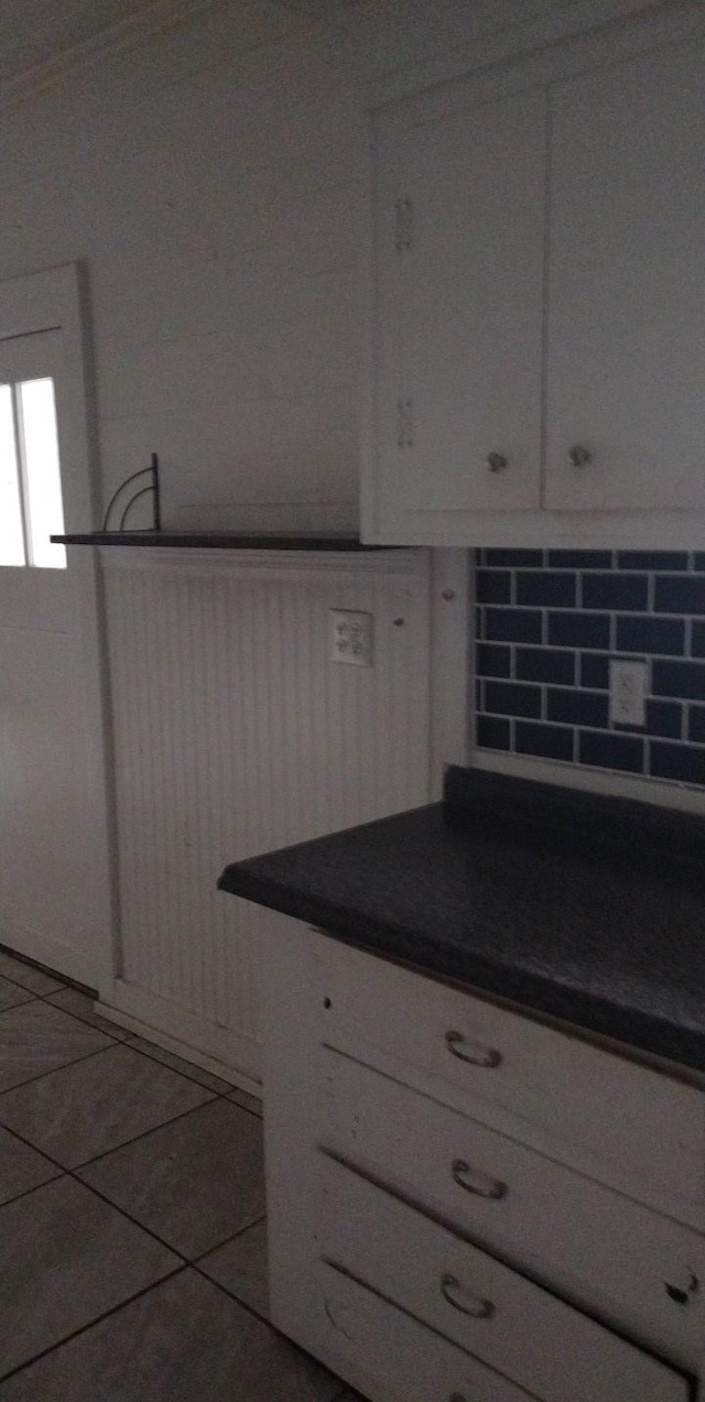 511 Chandler St, Minden, LA 71055 - kitchen with dark countertops, tasteful backsplash, tile patterned floors, and white cabinetry