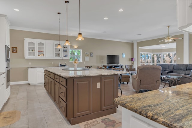 327 Saddle Club Rd, Weatherford, TX 76088 - kitchen featuring open floor plan, crown molding, a kitchen island, and glass insert cabinets
