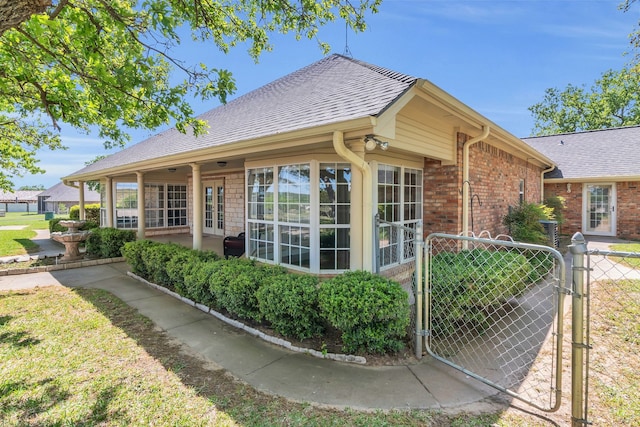 327 Saddle Club Rd, Weatherford, TX 76088 - view of side of home featuring fence, a shingled roof, a gate, and brick siding