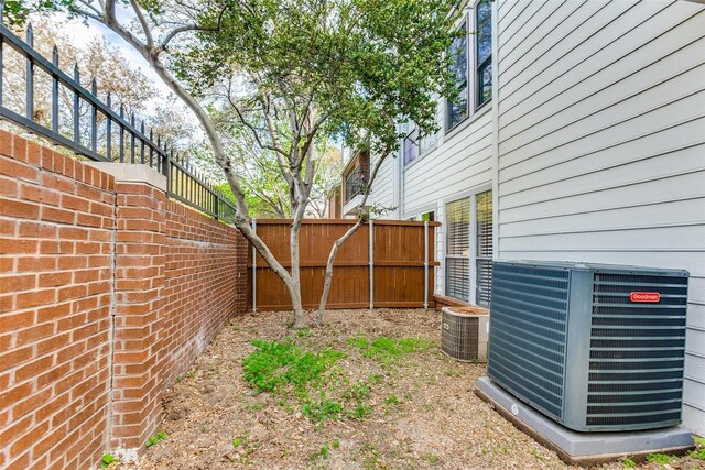 view of yard with central air condition unit and fence