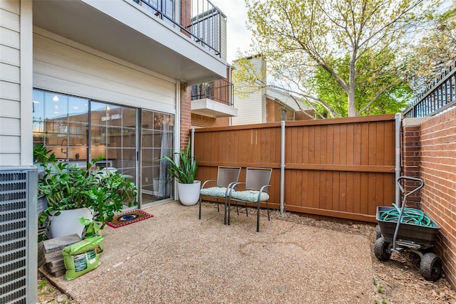 view of patio / terrace with central AC unit and fence