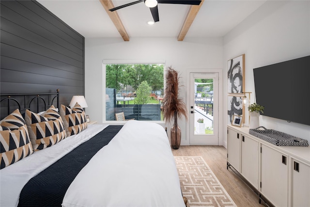 bedroom with access to exterior, light wood-type flooring, multiple windows, and beam ceiling