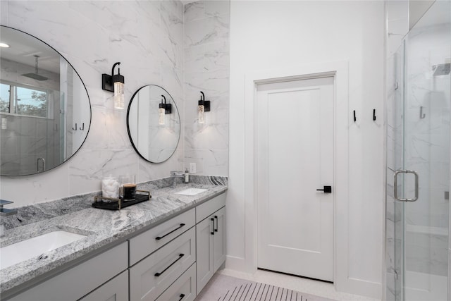 full bath with a sink, double vanity, backsplash, and a marble finish shower