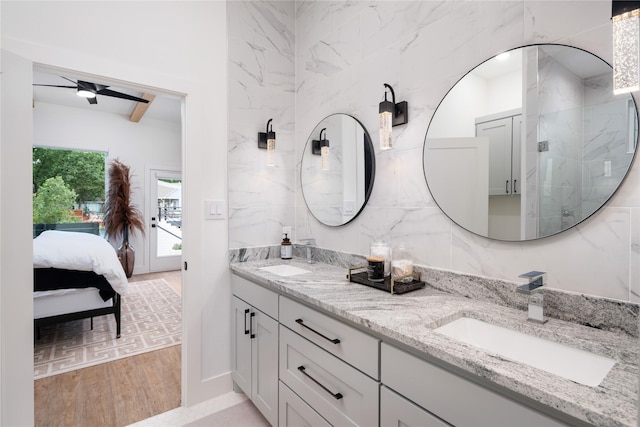 full bathroom featuring double vanity, ensuite bath, wood finished floors, and a sink
