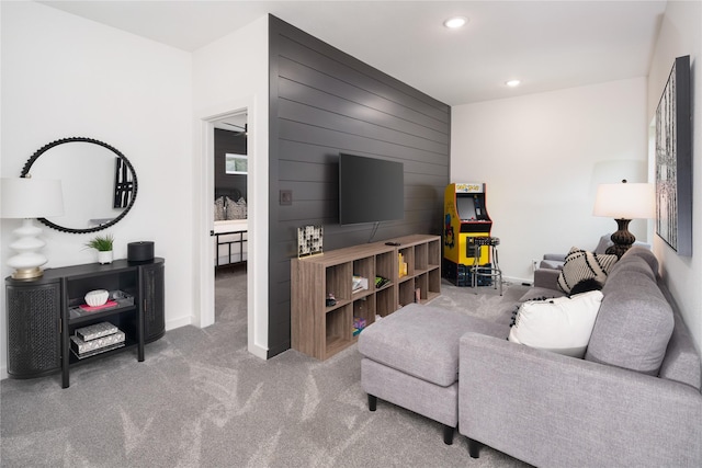 living area featuring baseboards, wooden walls, recessed lighting, and carpet