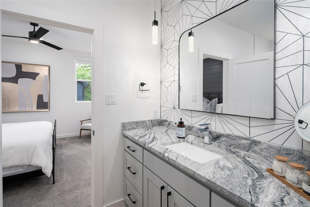 ensuite bathroom featuring a ceiling fan, baseboards, ensuite bath, and vanity