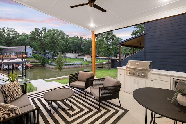 patio terrace at dusk featuring fence, a grill, ceiling fan, an outdoor hangout area, and a water view