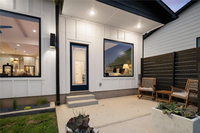 entrance to property with fence and board and batten siding