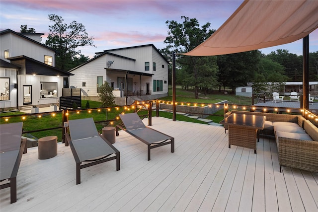 deck featuring a yard and an outdoor living space with a fire pit