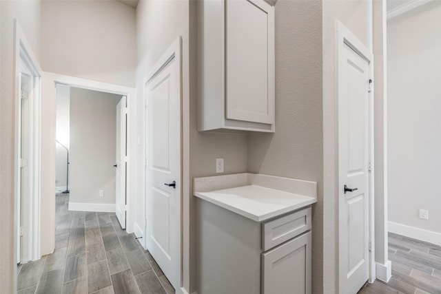 corridor featuring baseboards and wood finished floors