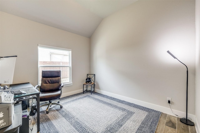 office space featuring wood finished floors, lofted ceiling, and baseboards